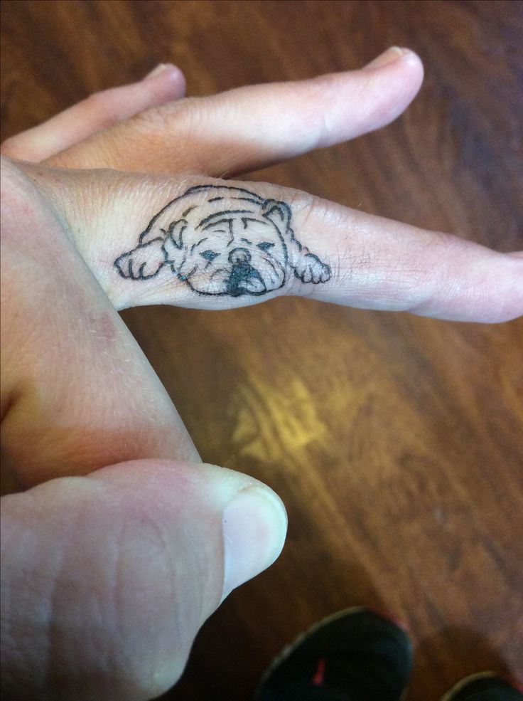 a person's hand with a dog tattoo on it