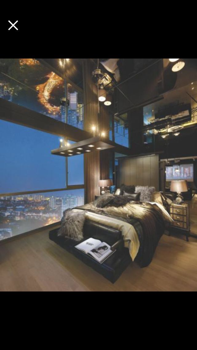 a bedroom with a large window overlooking the city at night and lit up by lights