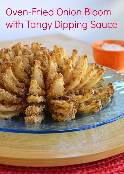 oven - fried onion bloom with tangy dipping sauce on a blue plate next to an orange bowl