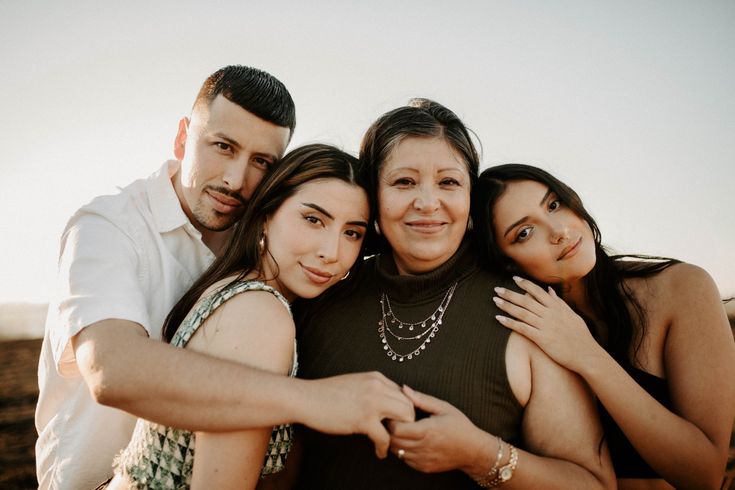 three women and one man are hugging each other