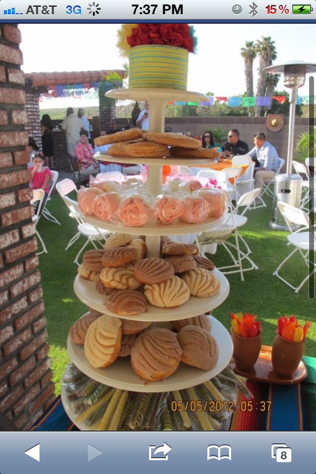 there is a cake and cookies on top of the three tiered trays that are stacked high