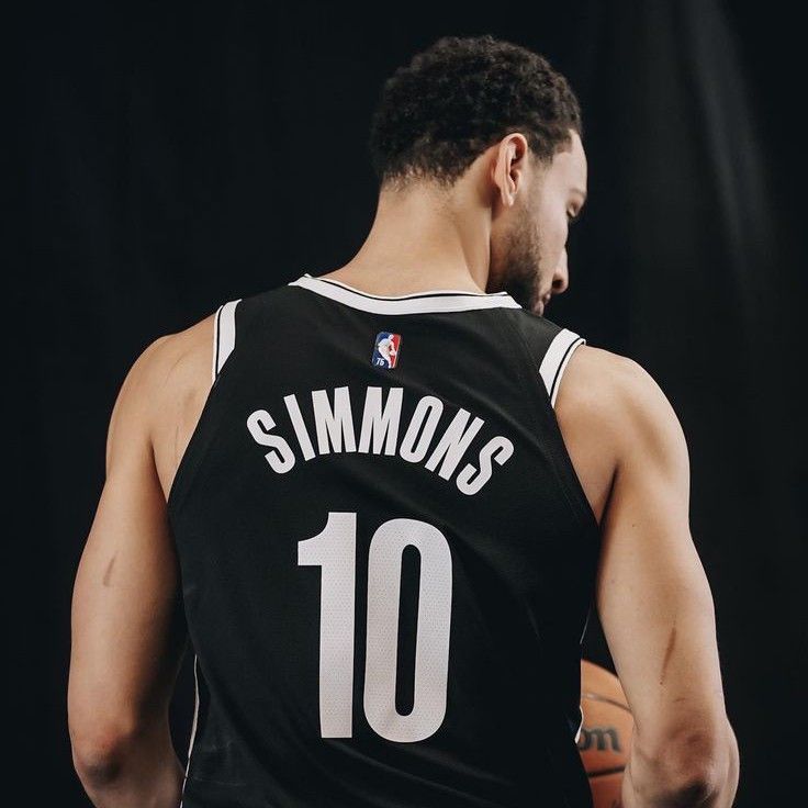 a man holding a basketball in his right hand and wearing a jersey with the number 10 on it