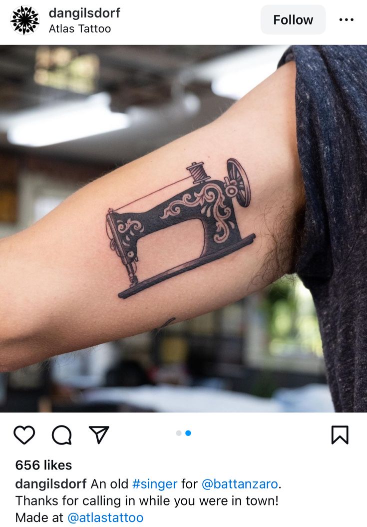 a person with a tattoo on their arm holding a sewing machine