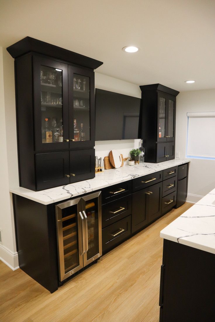 a kitchen with black cabinets and white counter tops