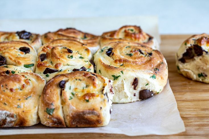 some bread rolls sitting on top of a wooden cutting board