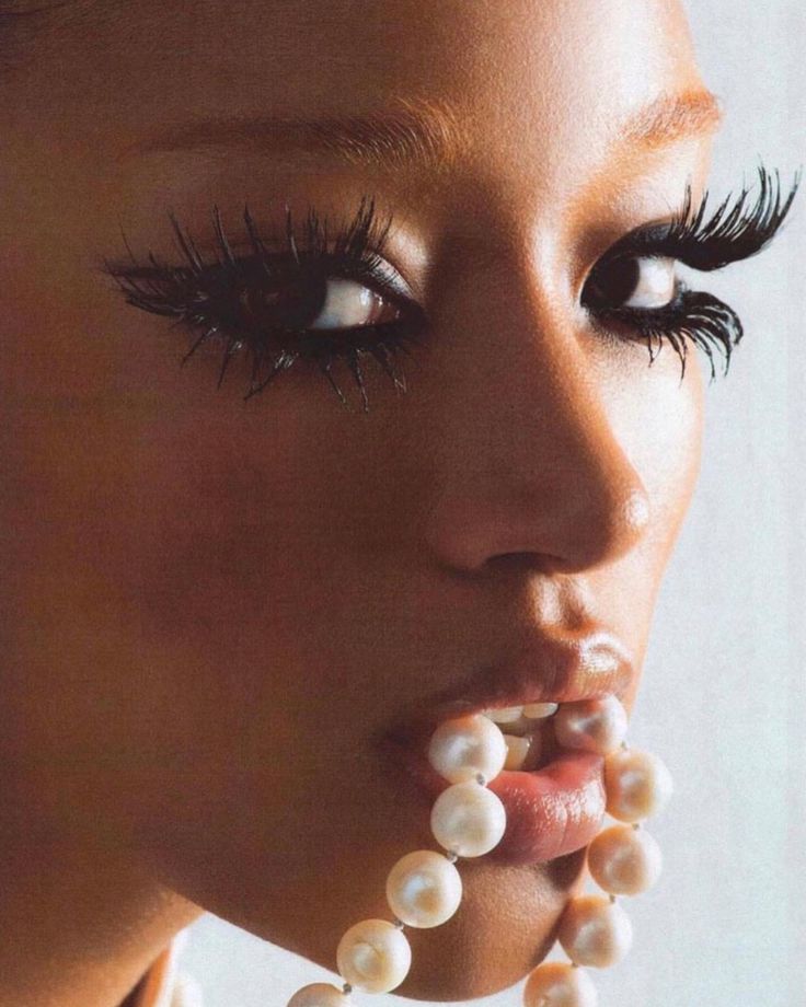 a woman with fake eyelashes and pearls on her face is shown in the instagram