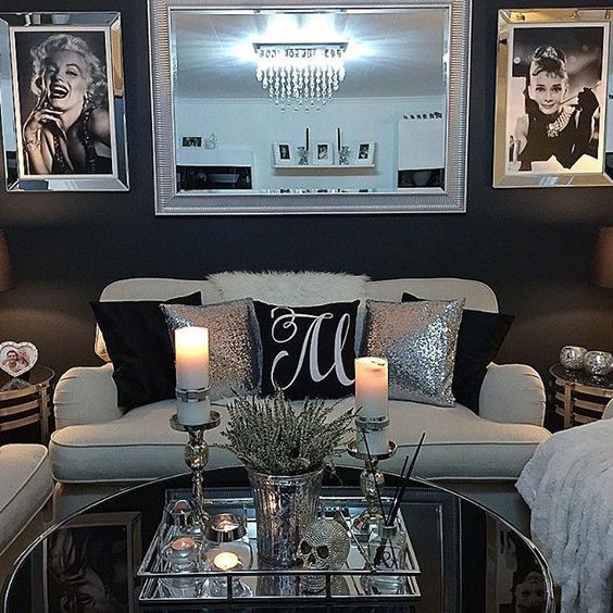 a living room with pictures on the wall and candles in front of the coffee table