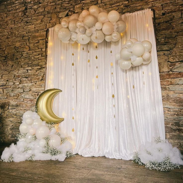 an image of a balloon arch and moon on the stage for a birthday party or baby's first birthday