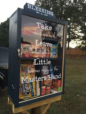 a sign that is on top of a wooden post in the grass with words written all over it