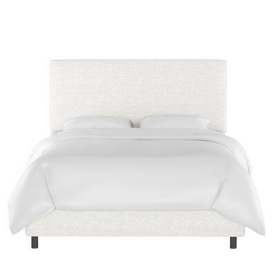 a bed with white linens and pillows on it's headboard, in front of a white background