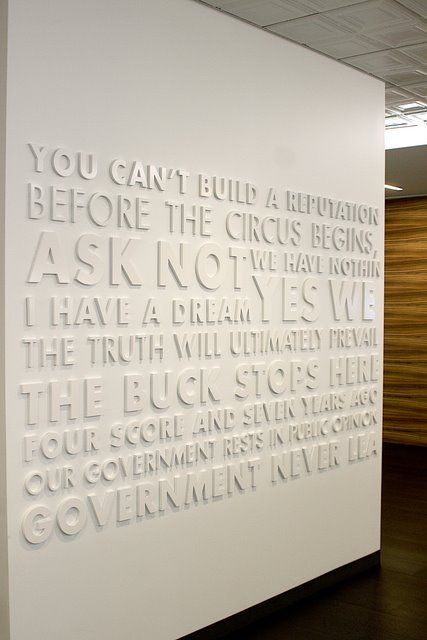 a white wall that has some type of writing on it in the middle of a room