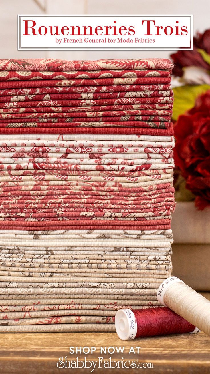 a stack of red and white fabric next to some flowers