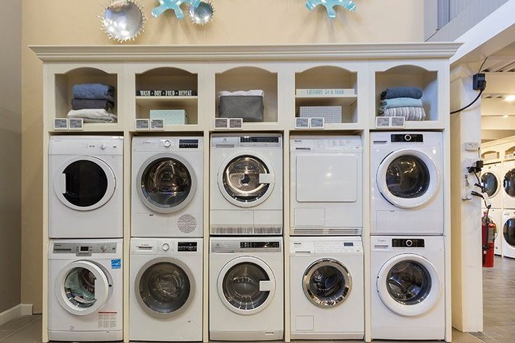 a row of washers and dryers in a laundry room