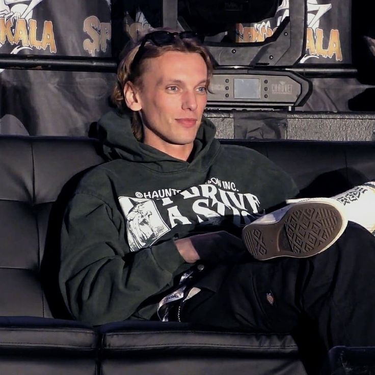 a man sitting on top of a black couch