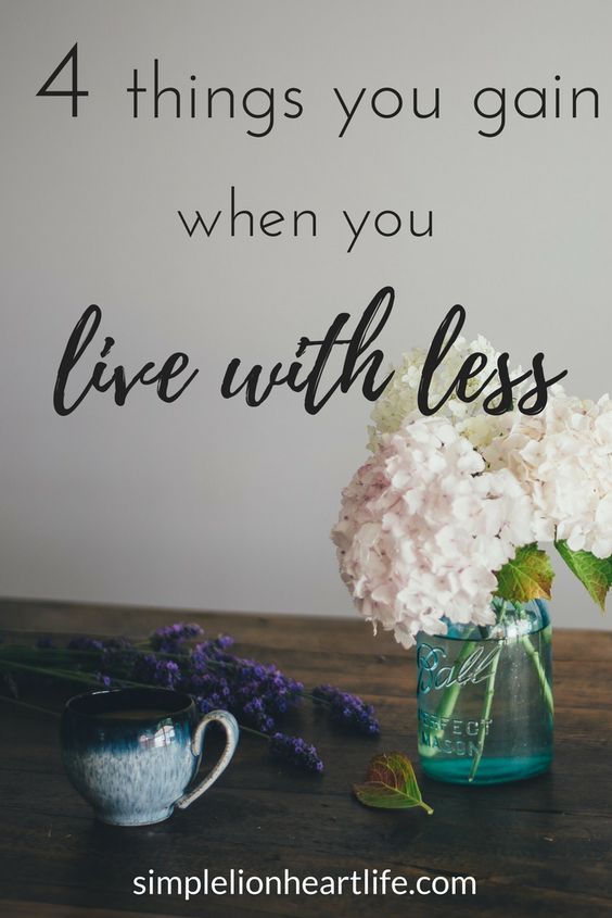 white flowers in a vase on a table with the words 4 things you gain when you live with less