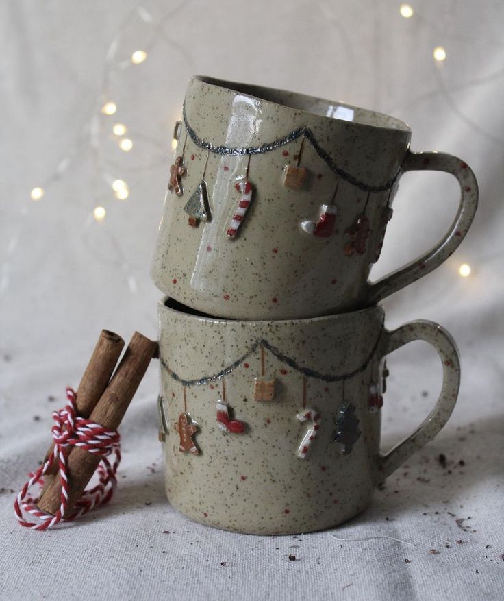 three coffee mugs stacked on top of each other with christmas decorations hanging from them