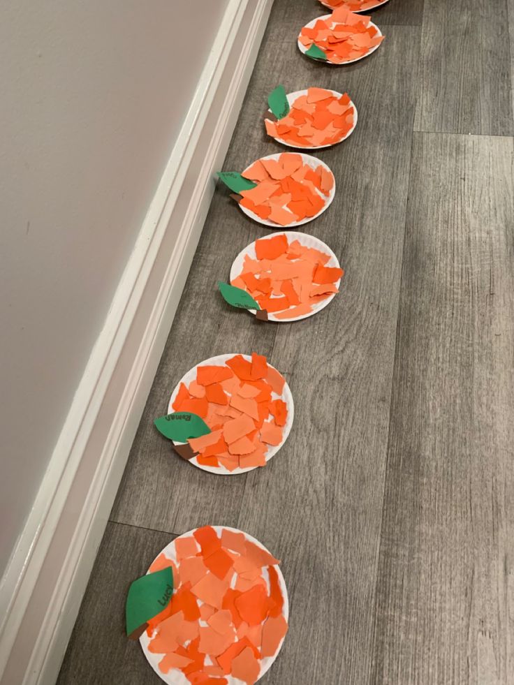 paper plates with carrots on them sitting on the floor next to a door way