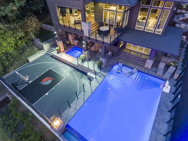 an aerial view of a large house with a basketball court in the middle of it