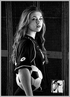 a young woman holding a soccer ball in her hands