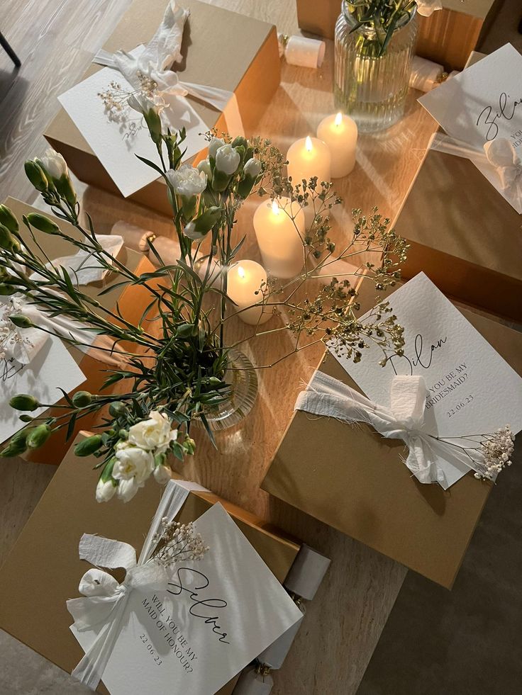 the table is set with candles and cards for guests to write their names or messages