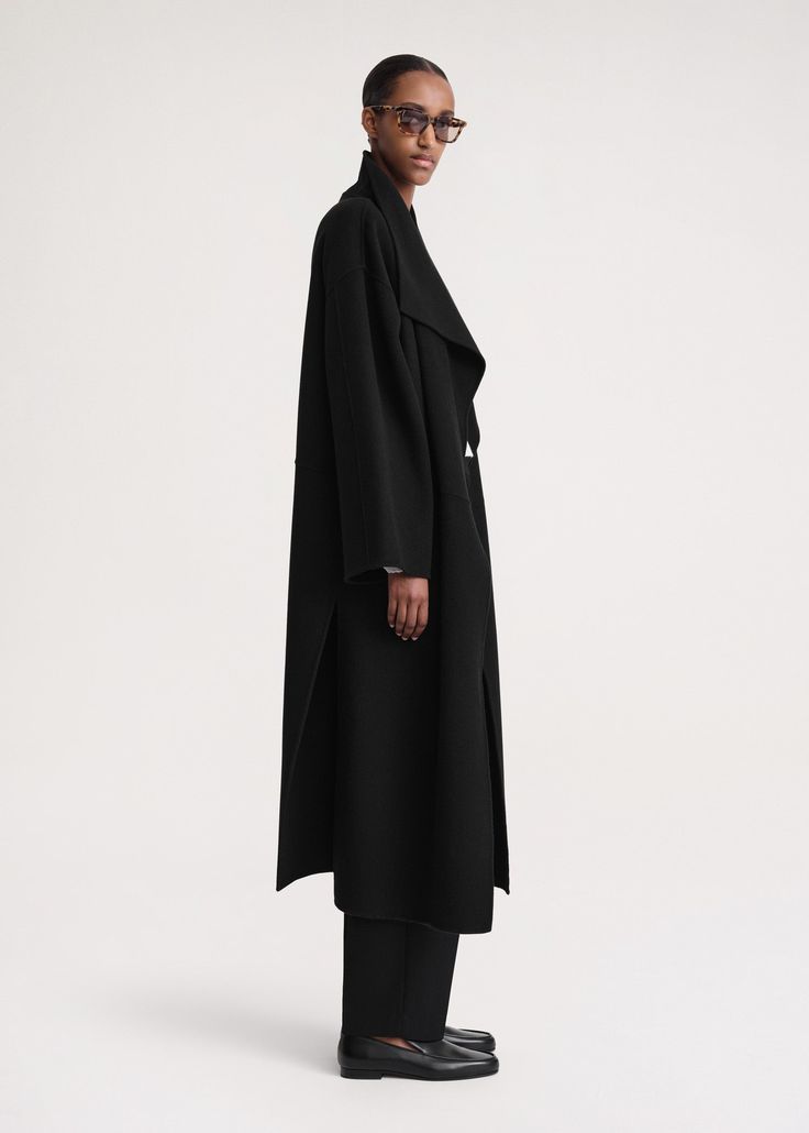 Signature coat crafted from TOTEME's soft doublé fabric – a blend of responsibly sourced wool and cashmere that's created by hand-stitching two fine layers together to achieve a double-faced finish with clean seams. It has an oversized silhouette with easy-to-style shawl lapels, dropped shoulders, and an open front that makes it perfect for layering, then is complete with inseam pockets and side slits. Coordinate it with the Long doublé scarf in the same color. Cashmere Fabric, Coat Black, Oversized Silhouette, Cashmere Coat, Issey Miyake, Jil Sander, Lanvin, Black Coat, Manolo Blahnik