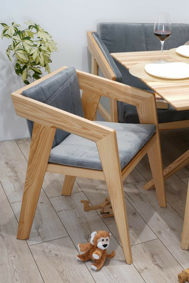 a wooden table with two chairs and a teddy bear on the floor