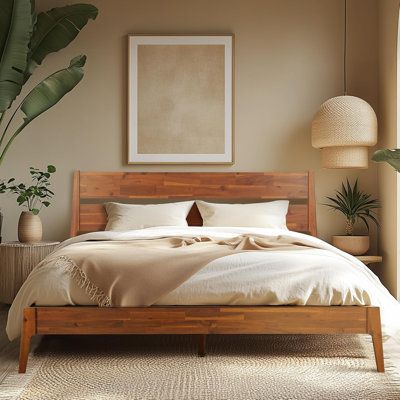 a large bed sitting next to a window in a room with potted plants on the side