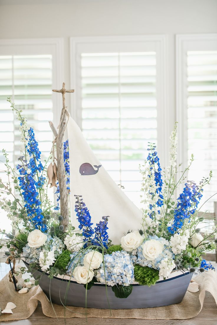 a blue and white flower arrangement in a boat