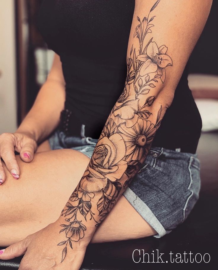 a woman is sitting on the floor with her arm tattoo