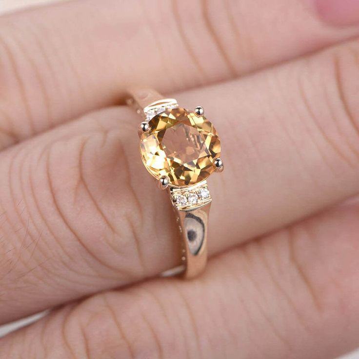 a woman's hand with a yellow diamond ring on it