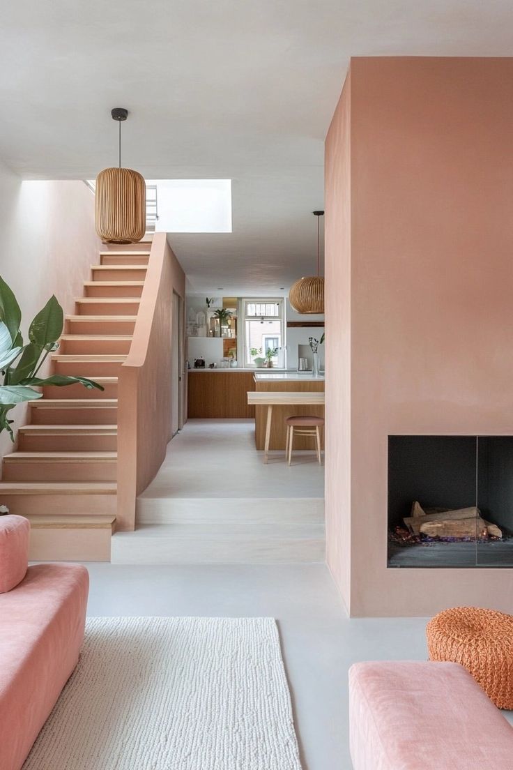 a living room filled with furniture and a fire place next to a stair case on the wall