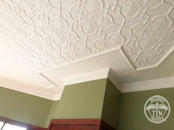 the ceiling is painted green and white with decorative designs on it, along with a window