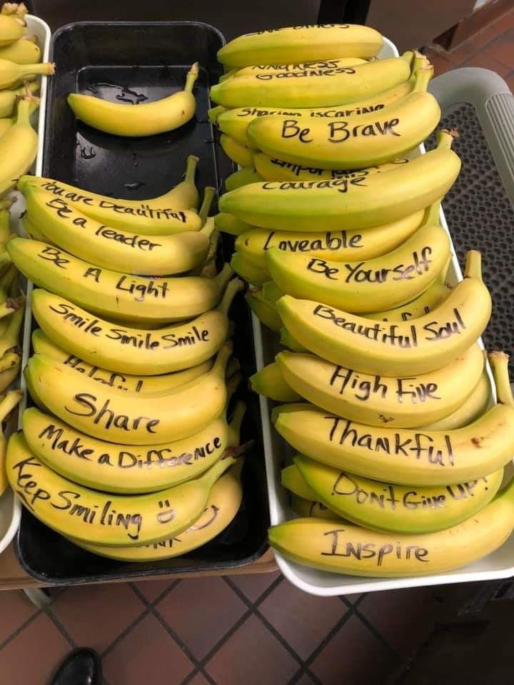 several bunches of bananas with words written on them sitting in a bin next to each other