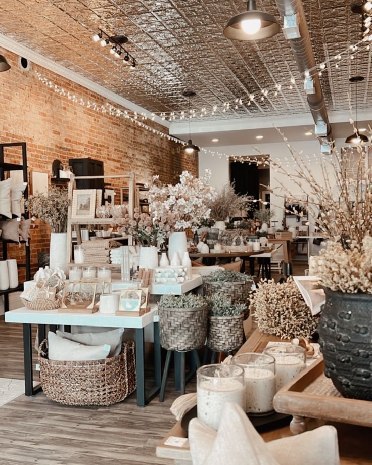 a room filled with lots of white flowers and baskets on the floor next to tables