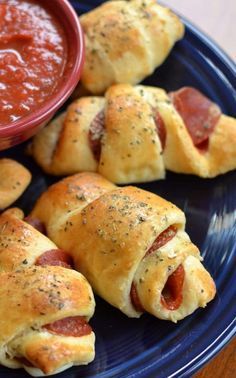 pigs in a blanket on a blue plate with dipping sauce and pepperoni dipper