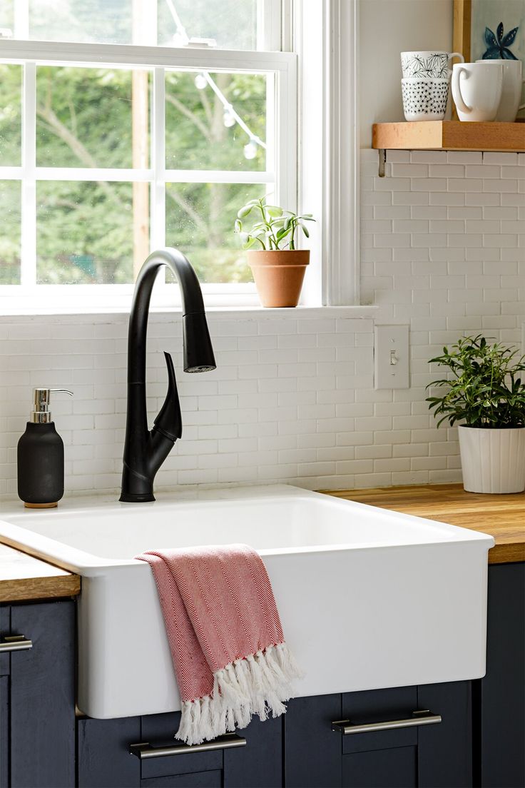 a white sink sitting under a window in a kitchen