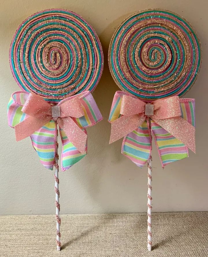 two candy lollipops with bows on them