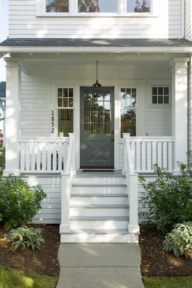 the front door of a white house with steps leading up to it's entrance