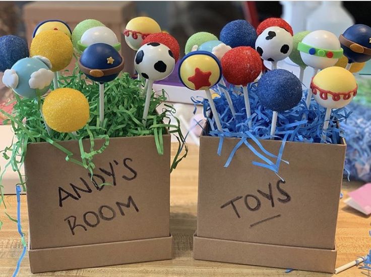 two cardboard boxes filled with cake pops on top of a table