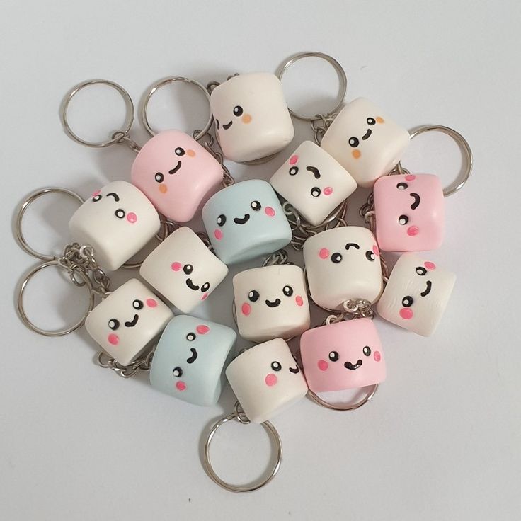 a bunch of key chains that have different faces on them, all in pastel colors