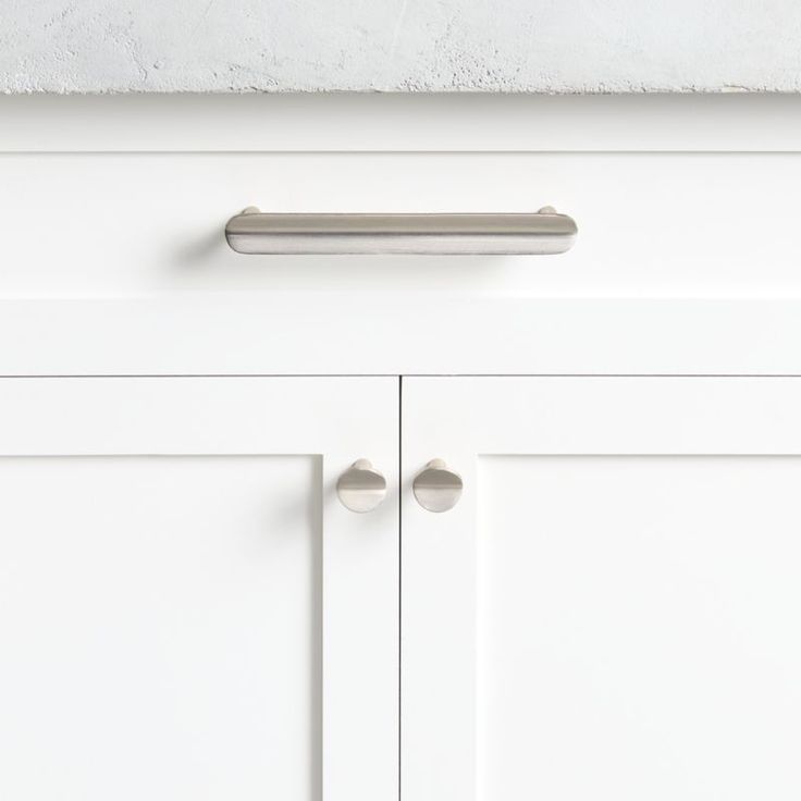 a white cabinet with two handles on it