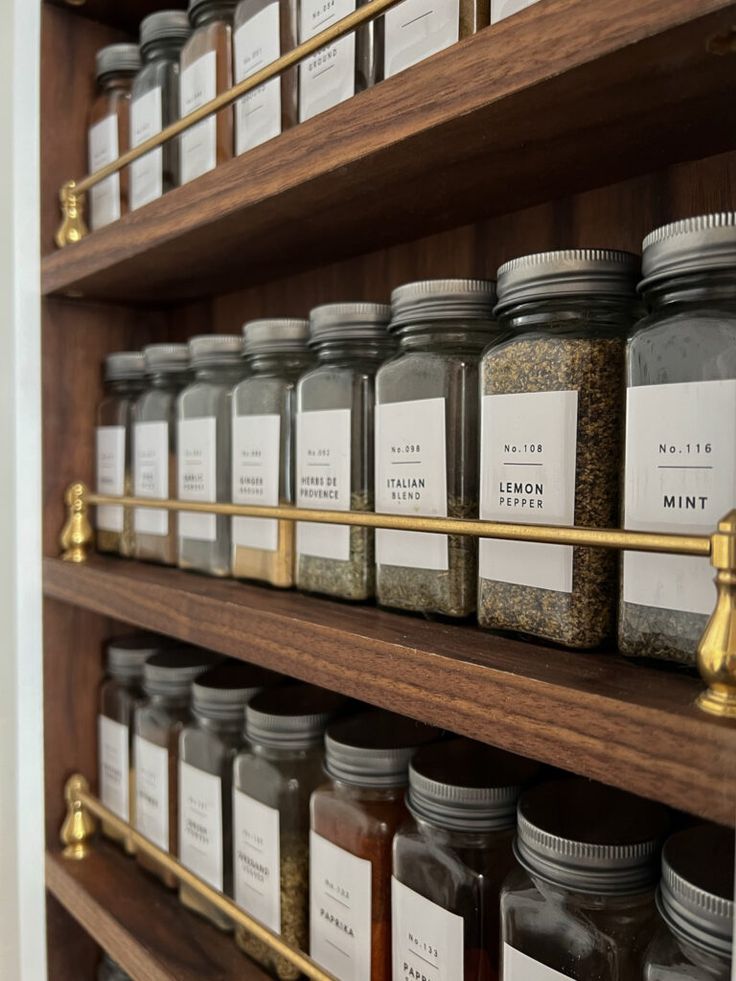 shelves filled with jars and spices on wooden shelves next to eachother's name tags