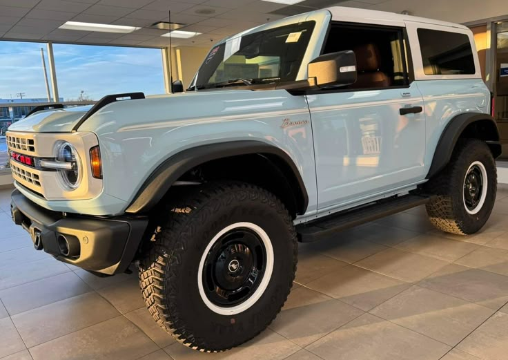 a light blue truck is parked in a showroom