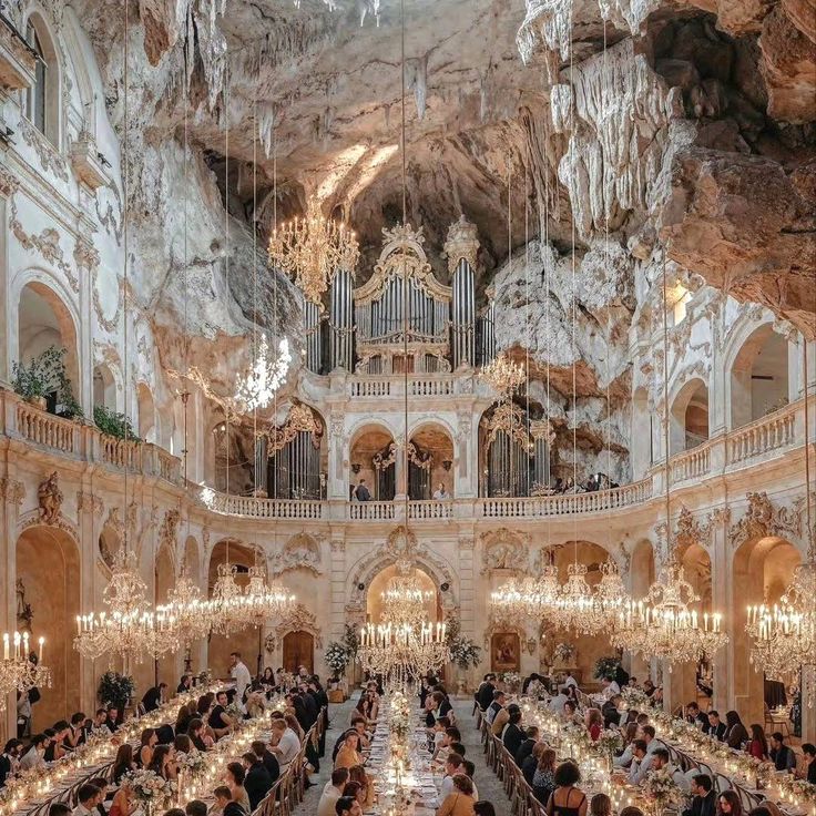 an ornately decorated dining hall with chandeliers and tables in front of the ceiling