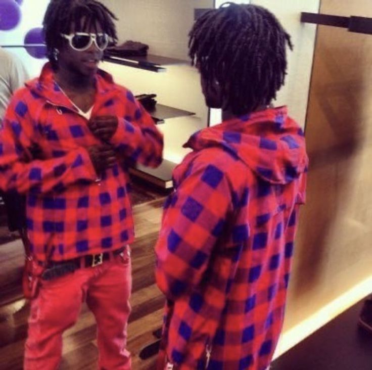 two young men standing in front of a mirror wearing red and blue checkered shirts