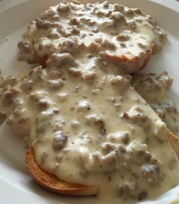 a white plate topped with meat covered in gravy