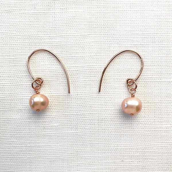 Cultured Freshwater Pearl & 14KT Rose-Gold Filled Earrings; Versatile to wear with a simple chain or a freshwater pearl necklace; Handcrafted in California Freshwater pearls are a light mauve, semi-round shape Earrings are 1" long with fishhook ear wires Each piece is hand-made No exchanges due to sanitary reasons Wear with the Freshwater Pearl & 14KT Rose Gold Necklace Cost-Saving Sparkle Set Bundle: These earrings are also part of the Pearl & Rose Gold Earring and Choker Set. ~ Necklace not in Dainty Rose Gold Round Pearl Earrings, Dainty Rose Gold Pearl Earrings, Delicate Hypoallergenic Rose Gold Pearl Earrings, Minimalist Rose Gold Round Pearl Earrings, Dainty Rose Gold Pearl Earrings For Gift, Dainty Rose Gold Pearl Earrings As Gift, Rose Gold Pearl Round Earrings, Minimalist Hypoallergenic Rose Gold Pearl Earrings, Hypoallergenic Minimalist Rose Gold Pearl Earrings