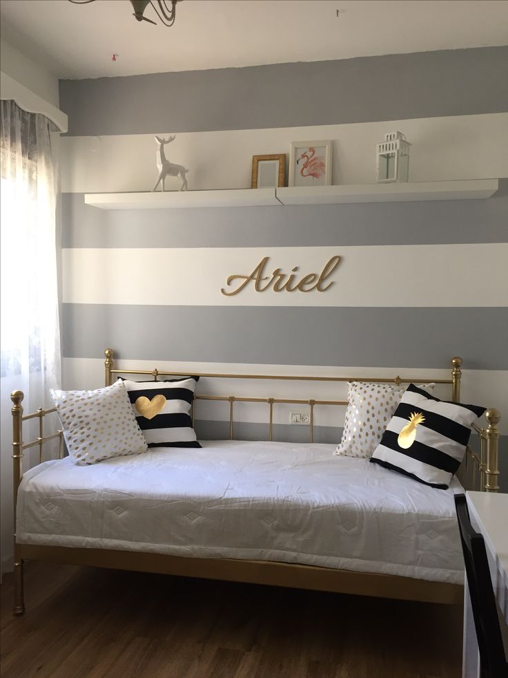 a bedroom with striped walls and white bedding