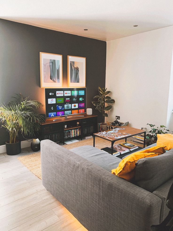 a living room filled with furniture and a flat screen tv sitting on top of a wooden table