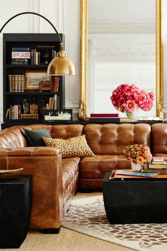 a living room filled with lots of furniture and a large mirror on the wall above it